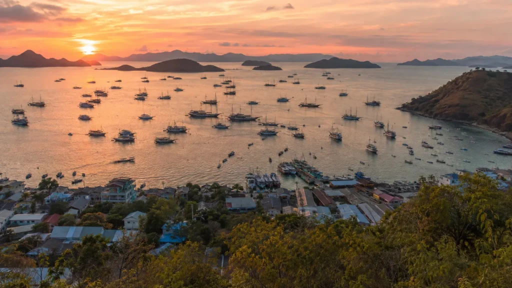 Phinisi boats moored in Labuan Bajo harbour at sunset, gateway to Komodo